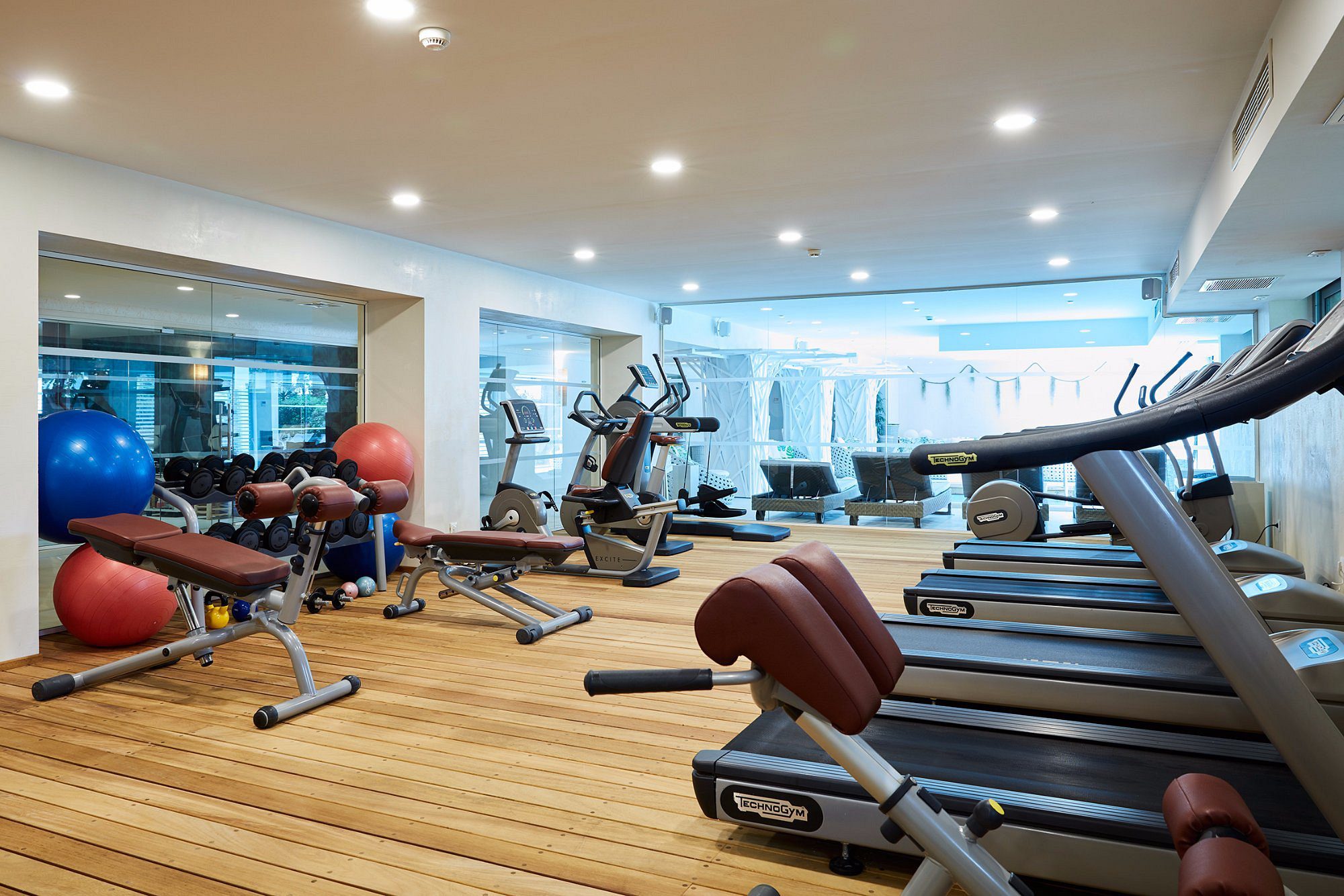 Modern gym with various exercise machines and bright lighting.
