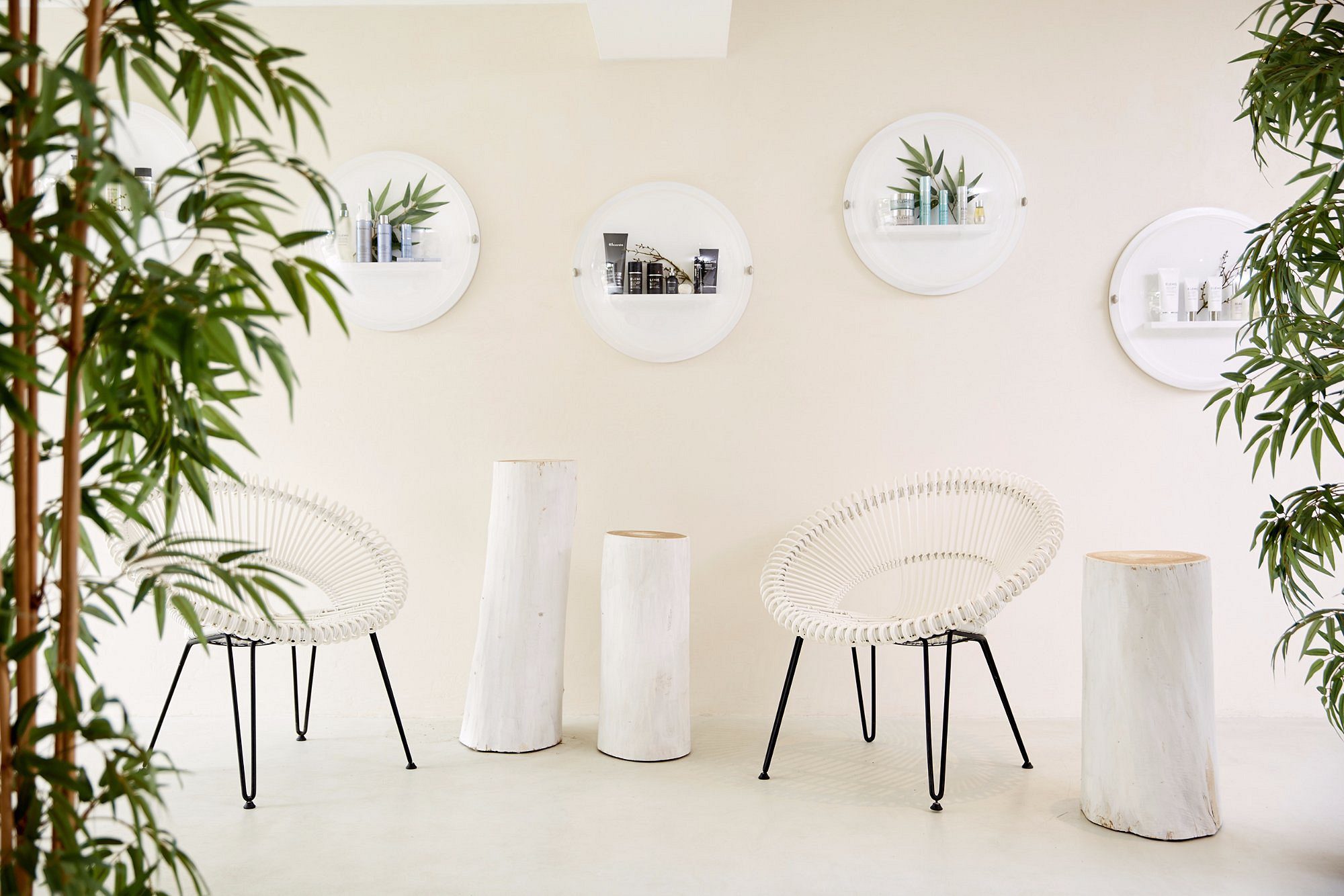 Minimalist white chairs and plants in a bright, airy room.