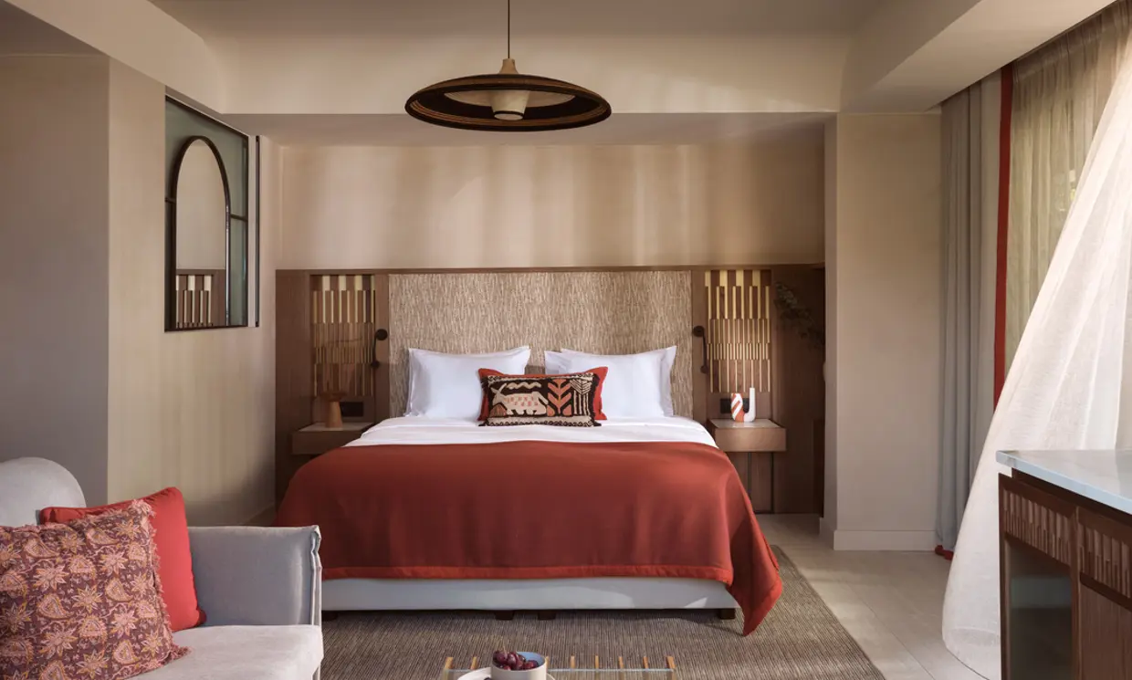 Cozy bedroom with a wooden headboard and rust-colored bedding.
