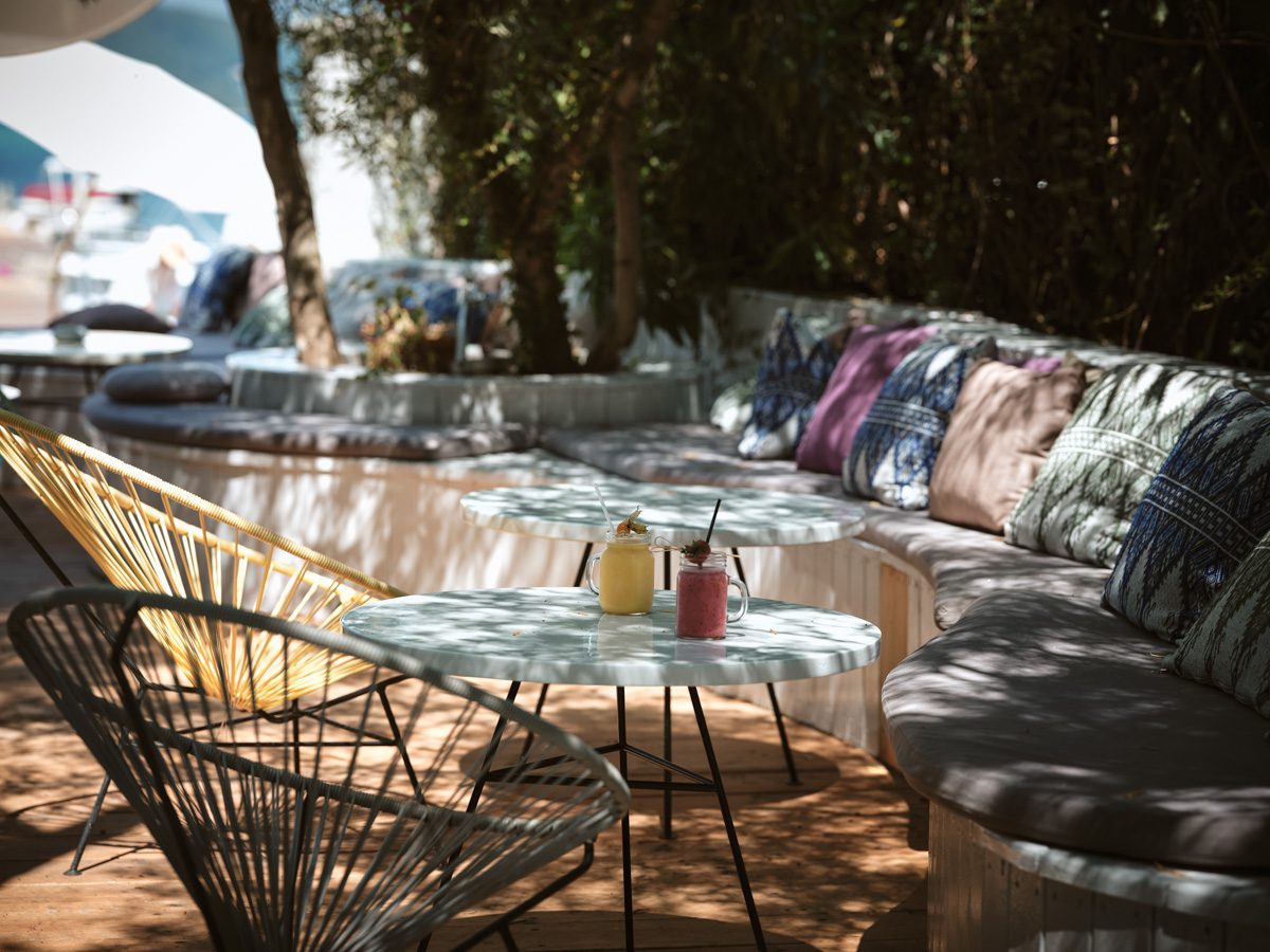 Cozy outdoor seating area with cushions and a shaded table.
