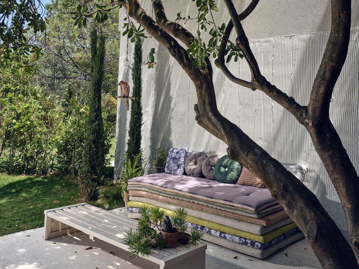 Cozy outdoor seating area with cushions and greenery.