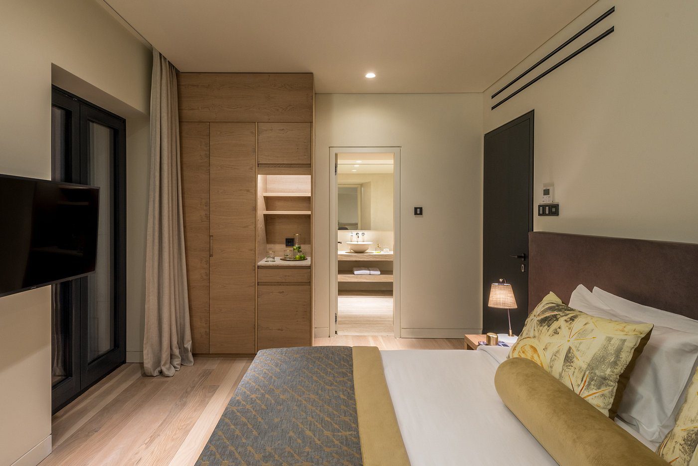 Modern bedroom with wooden accents and soft lighting.