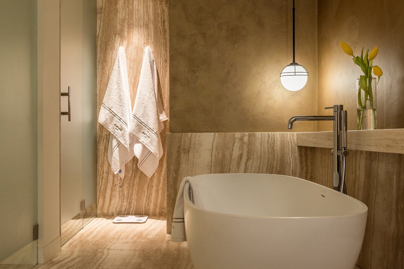 Elegant bathroom with a freestanding tub and hanging towels.
