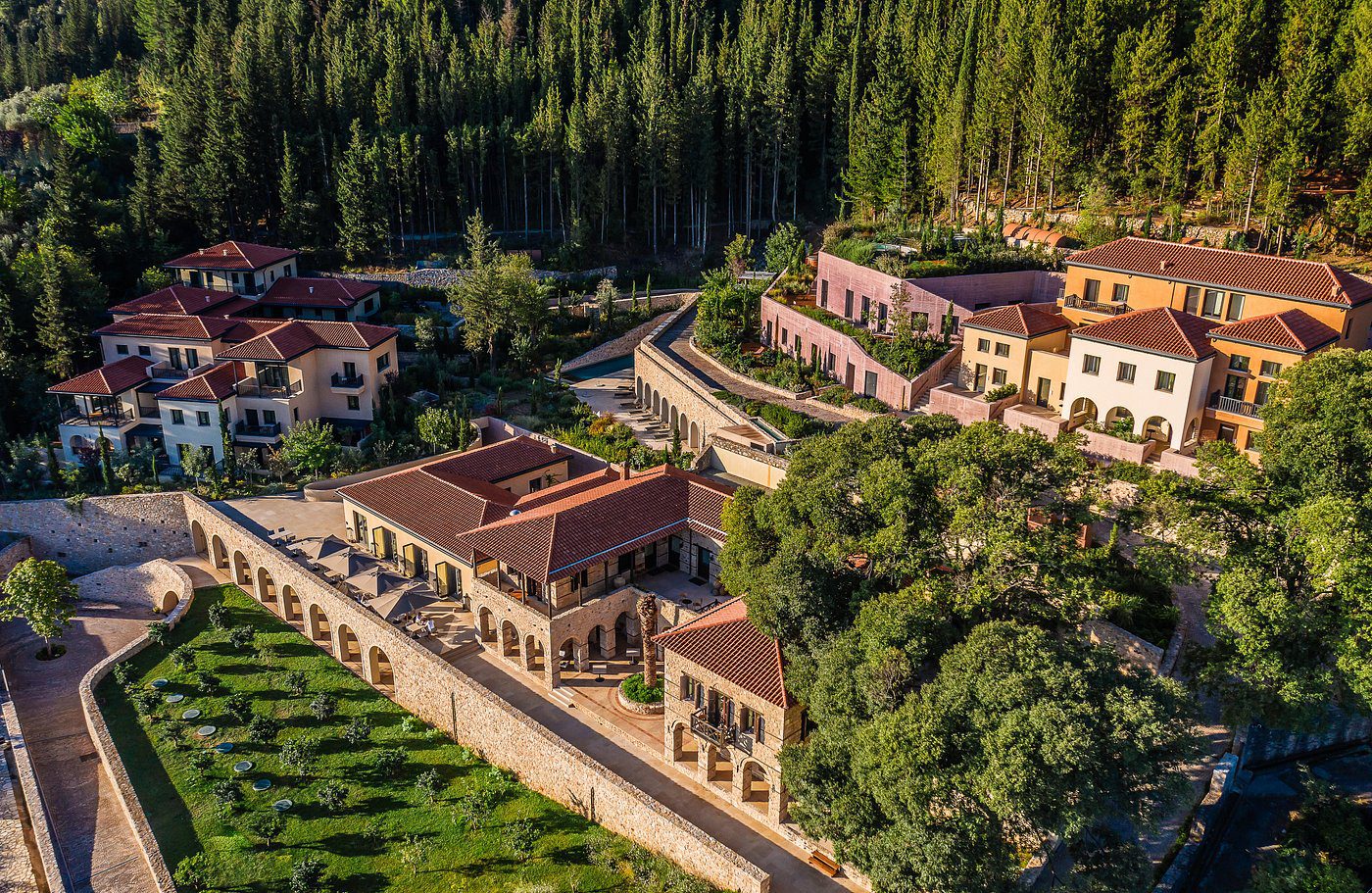 Aerial view of a luxurious villa surrounded by lush greenery and trees.