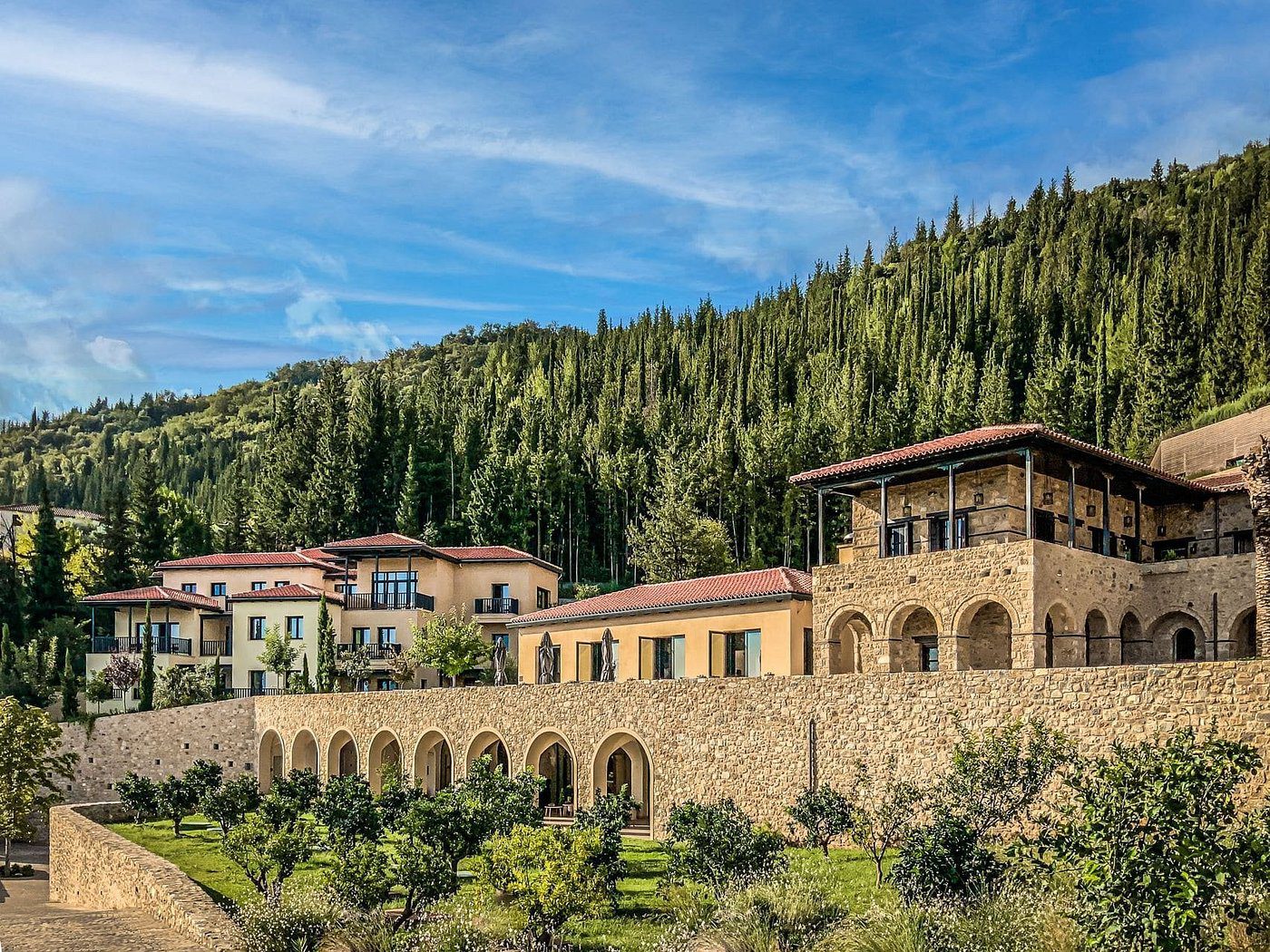 Euphoria Retreat luxury wellness spa nestled in the hills of Mystras, Greece, surrounded by forested hills.