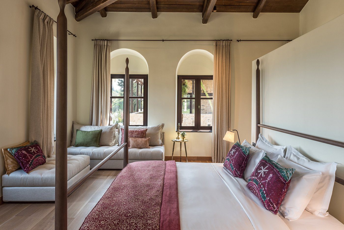 Cozy bedroom with a canopy bed and large windows letting in natural light.