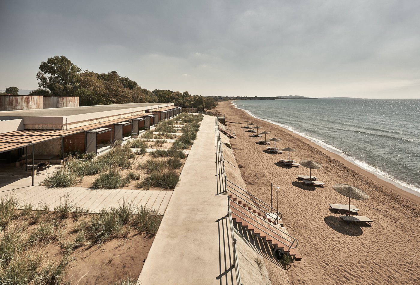 A peaceful beach with straw umbrellas and wooden walkways.