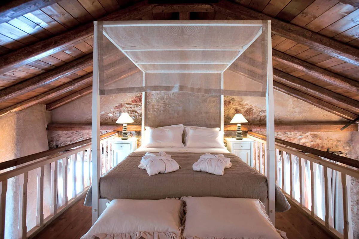 Cozy bedroom with rustic wooden ceiling and elegant canopy bed.