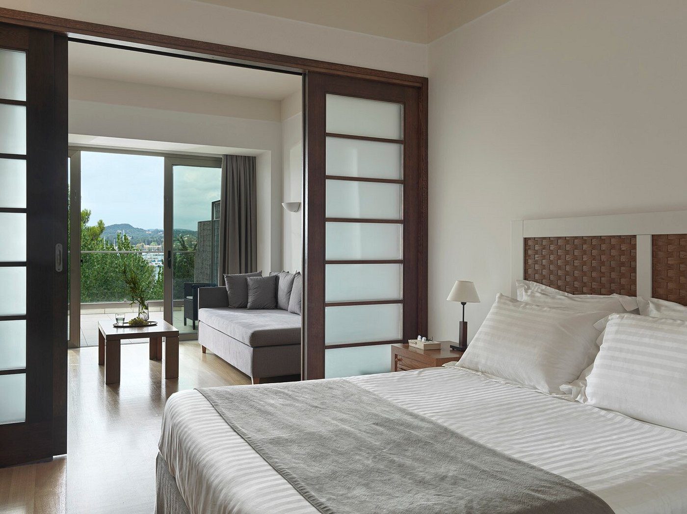 Modern bedroom with sliding glass doors and a cozy seating area.