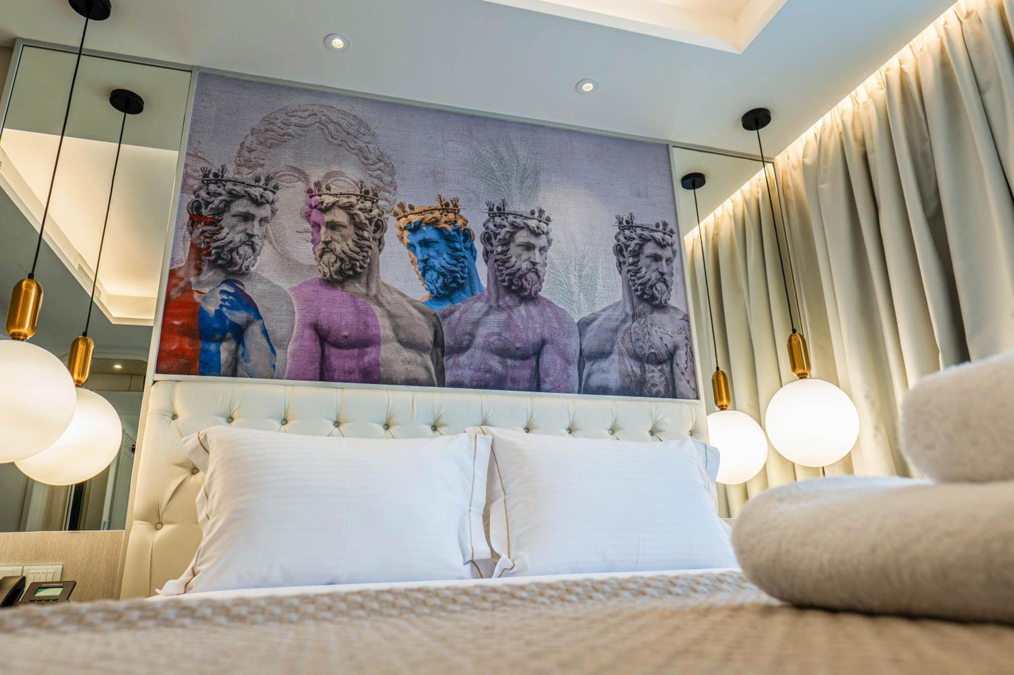 Modern bedroom with artistic statue mural above bed and elegant lighting.