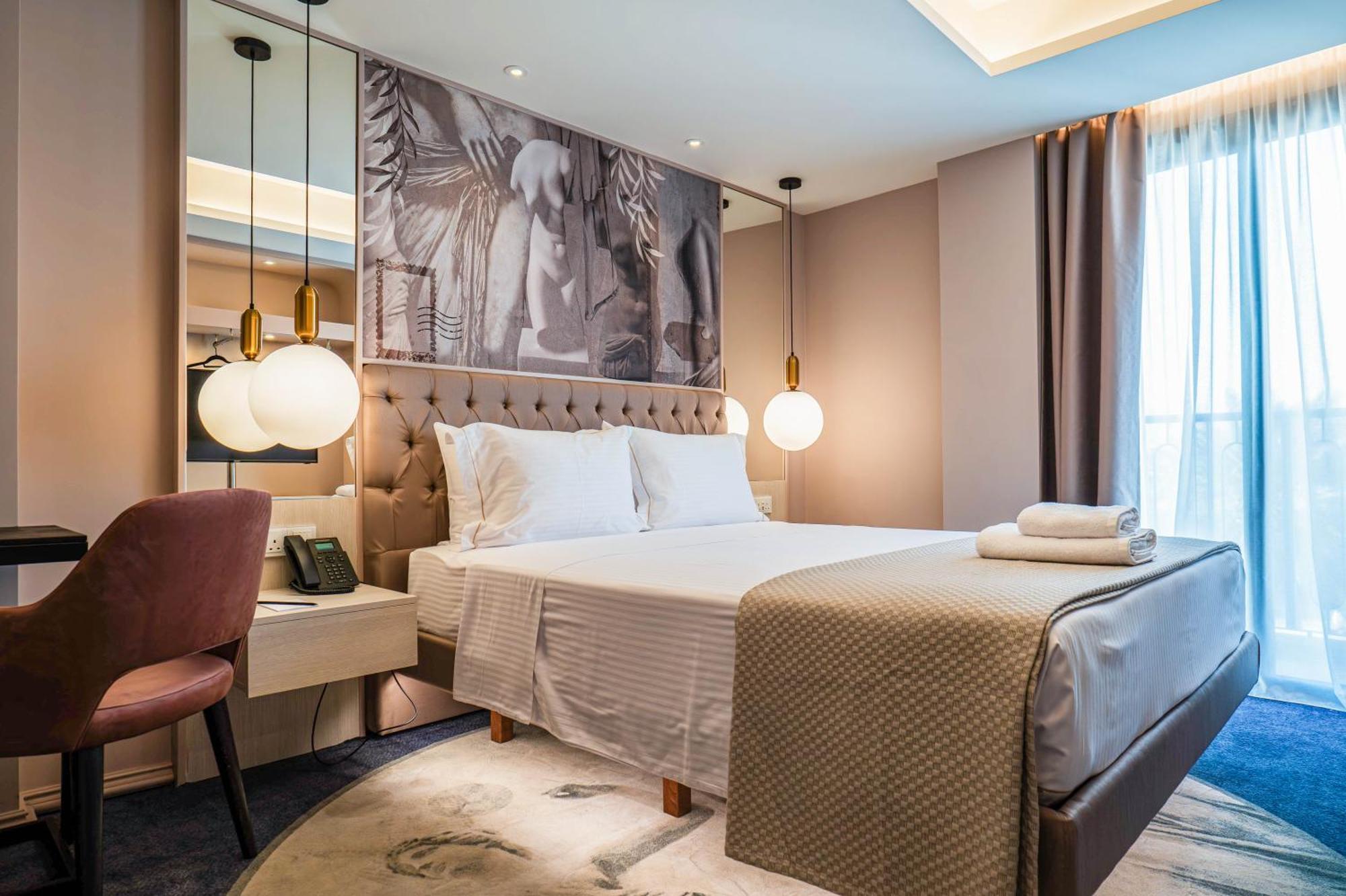 Elegant bedroom with neutral tones and modern lighting.