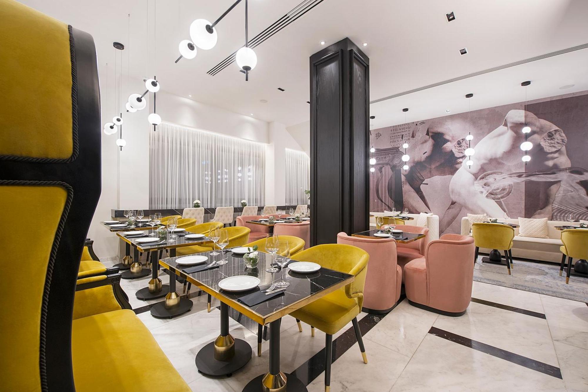 Modern restaurant interior with yellow chairs and elegant table settings.