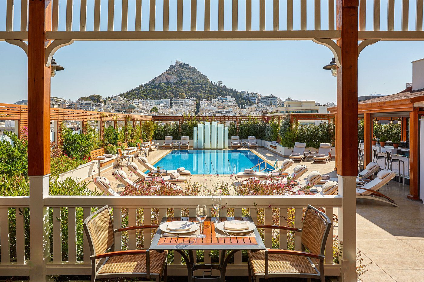 Scenic poolside view overlooking a hilltop from a restaurant balcony.