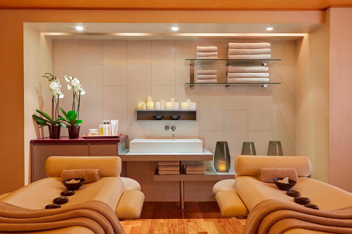 Cozy living room with beige sofas and stylish wall shelves.