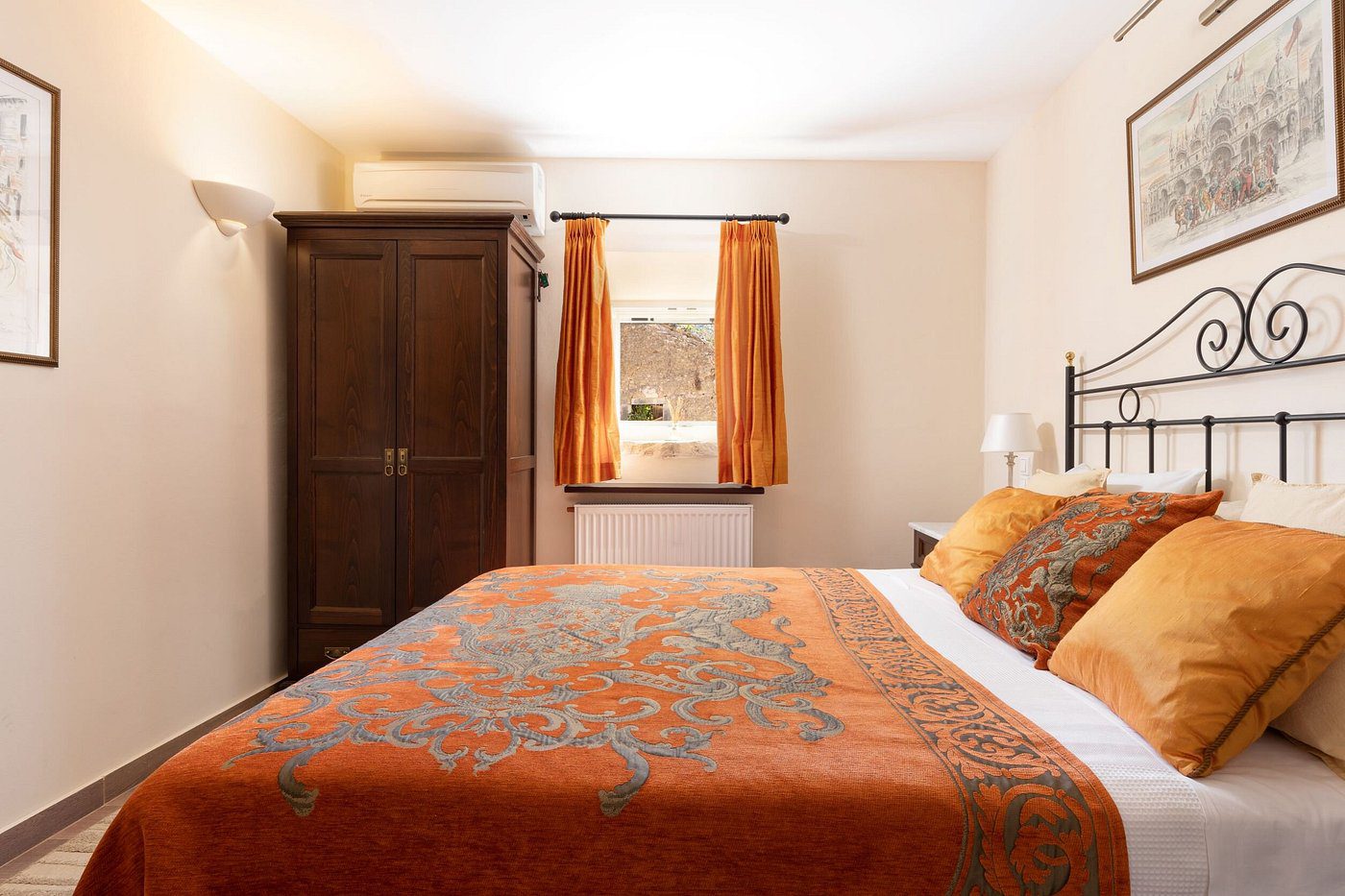 Cozy bedroom with orange bedding and curtains.