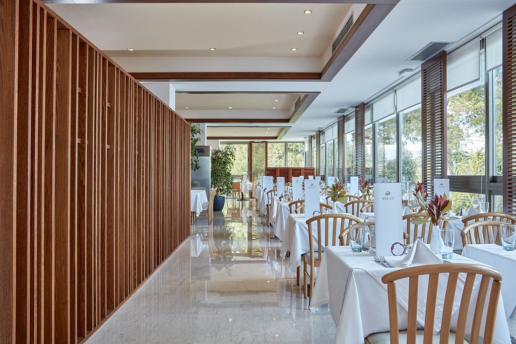 Elegant restaurant interior with wooden accents and white table settings.
