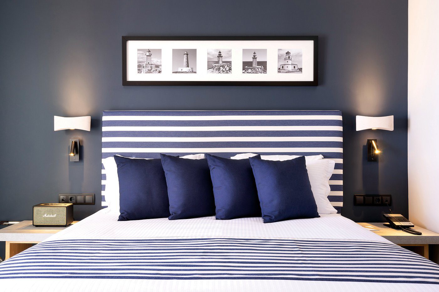 Modern bed with striped headboard and navy blue pillows.