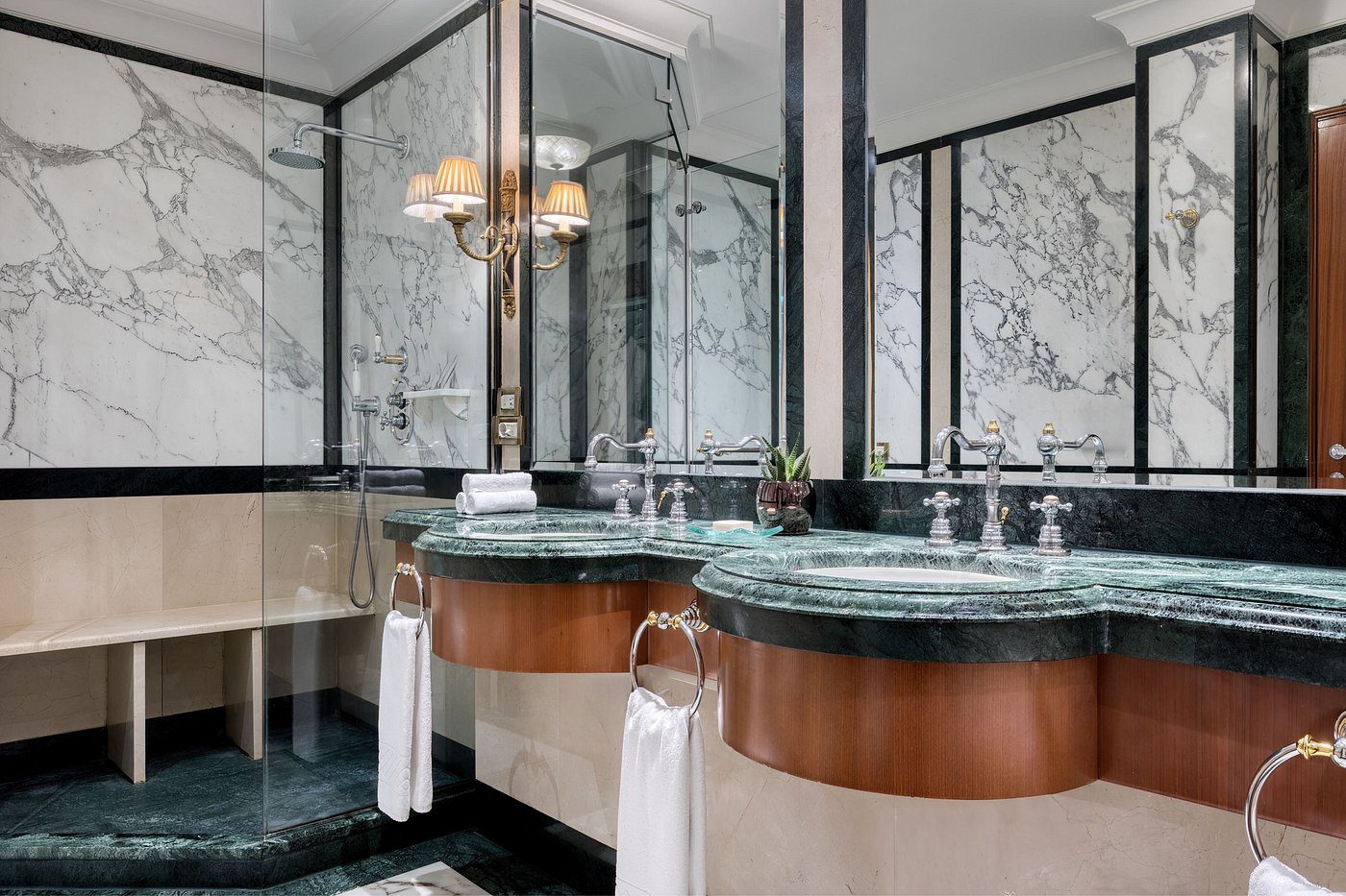 Elegant bathroom with marble walls and green stone sinks.