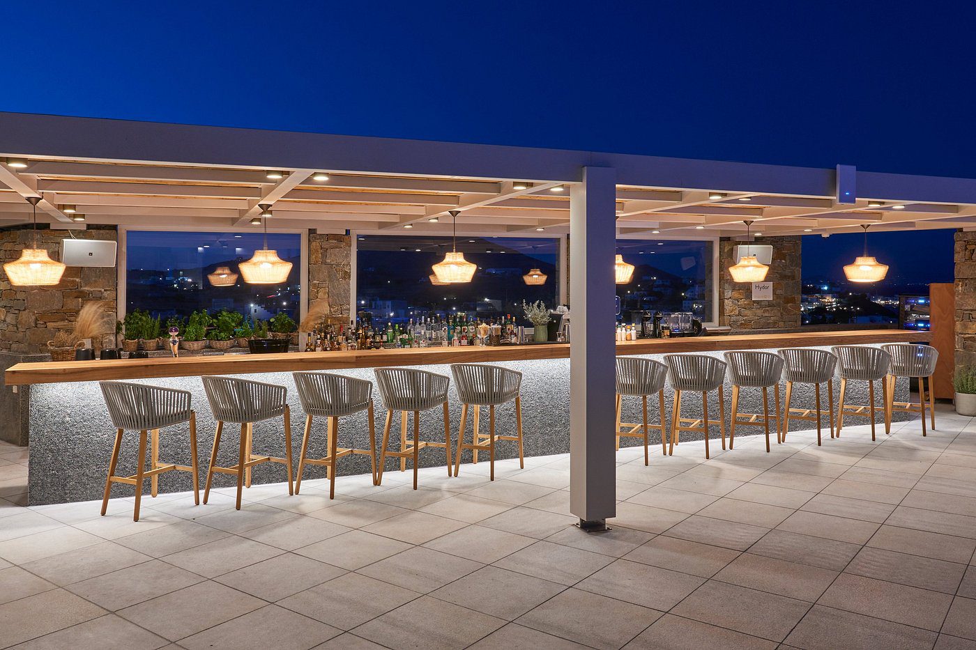 Stylish outdoor bar with cityscape view at dusk.