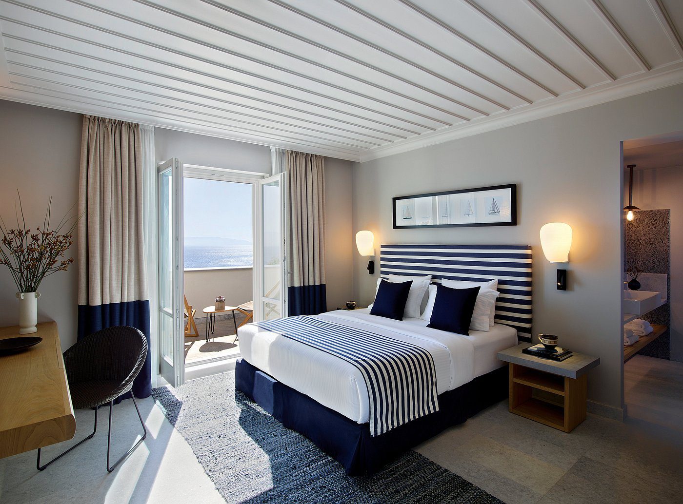 Modern bedroom with ocean view and cozy decor.