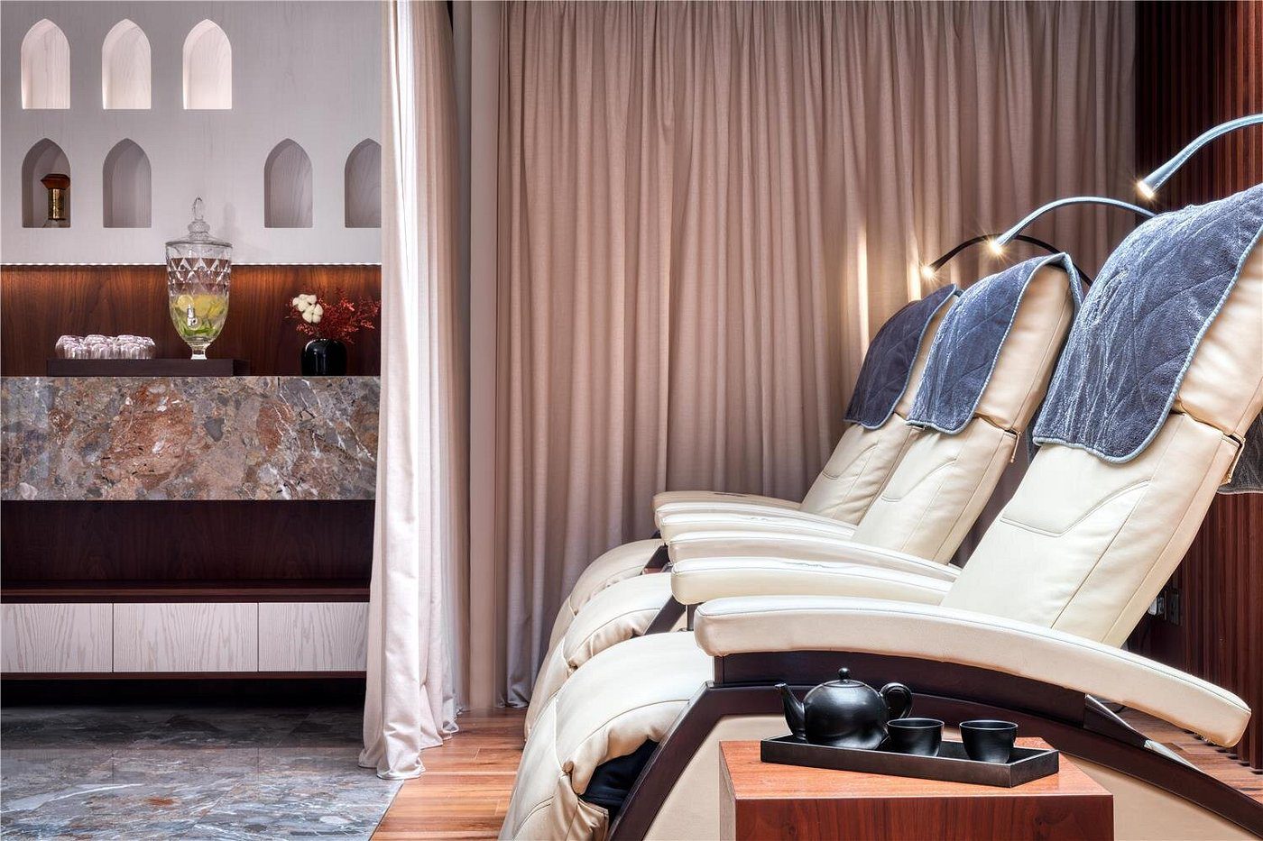 A cozy massage chair setup with soft curtains and calming decor.