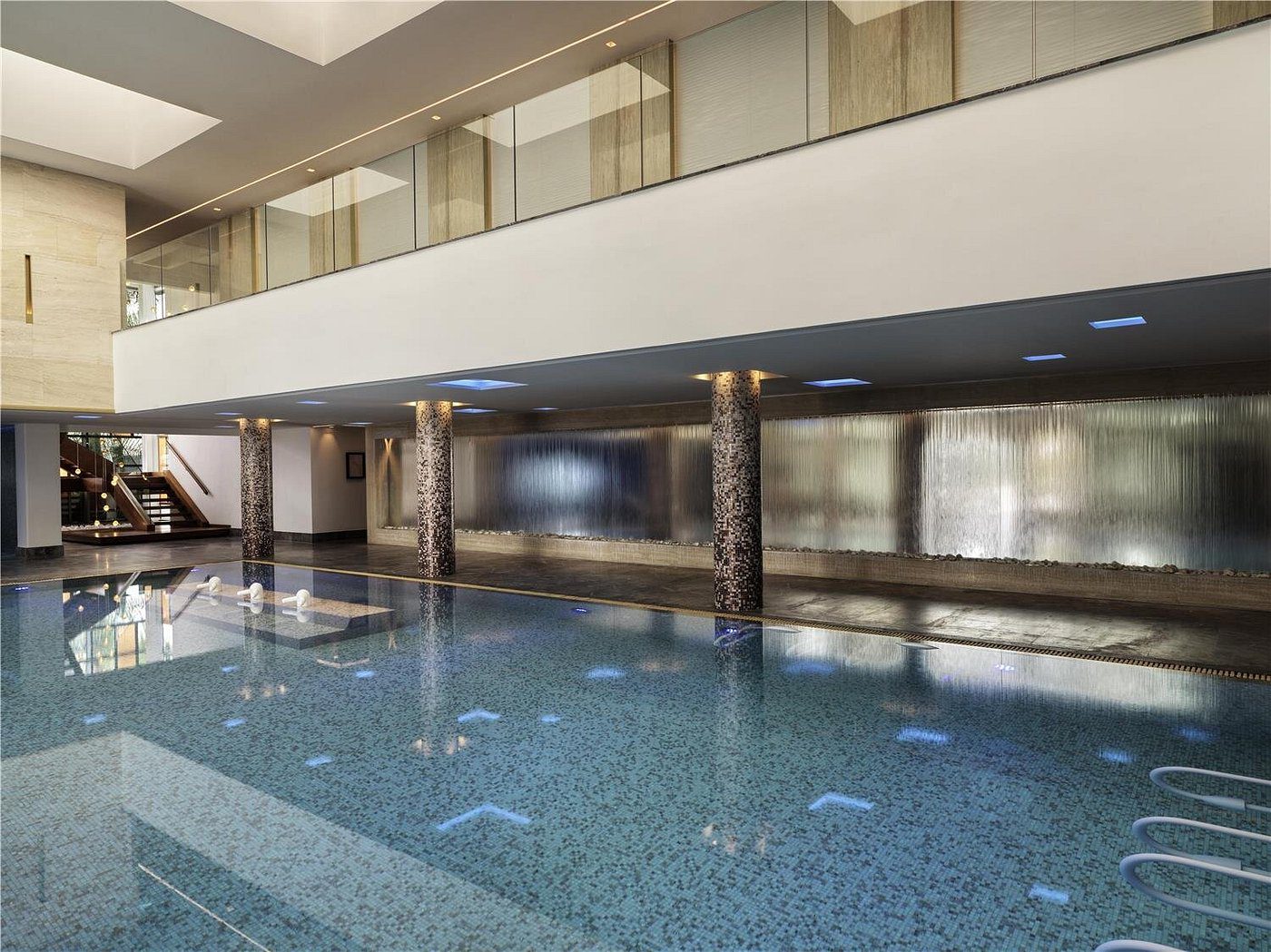 Indoor swimming pool with modern design and large windows.
