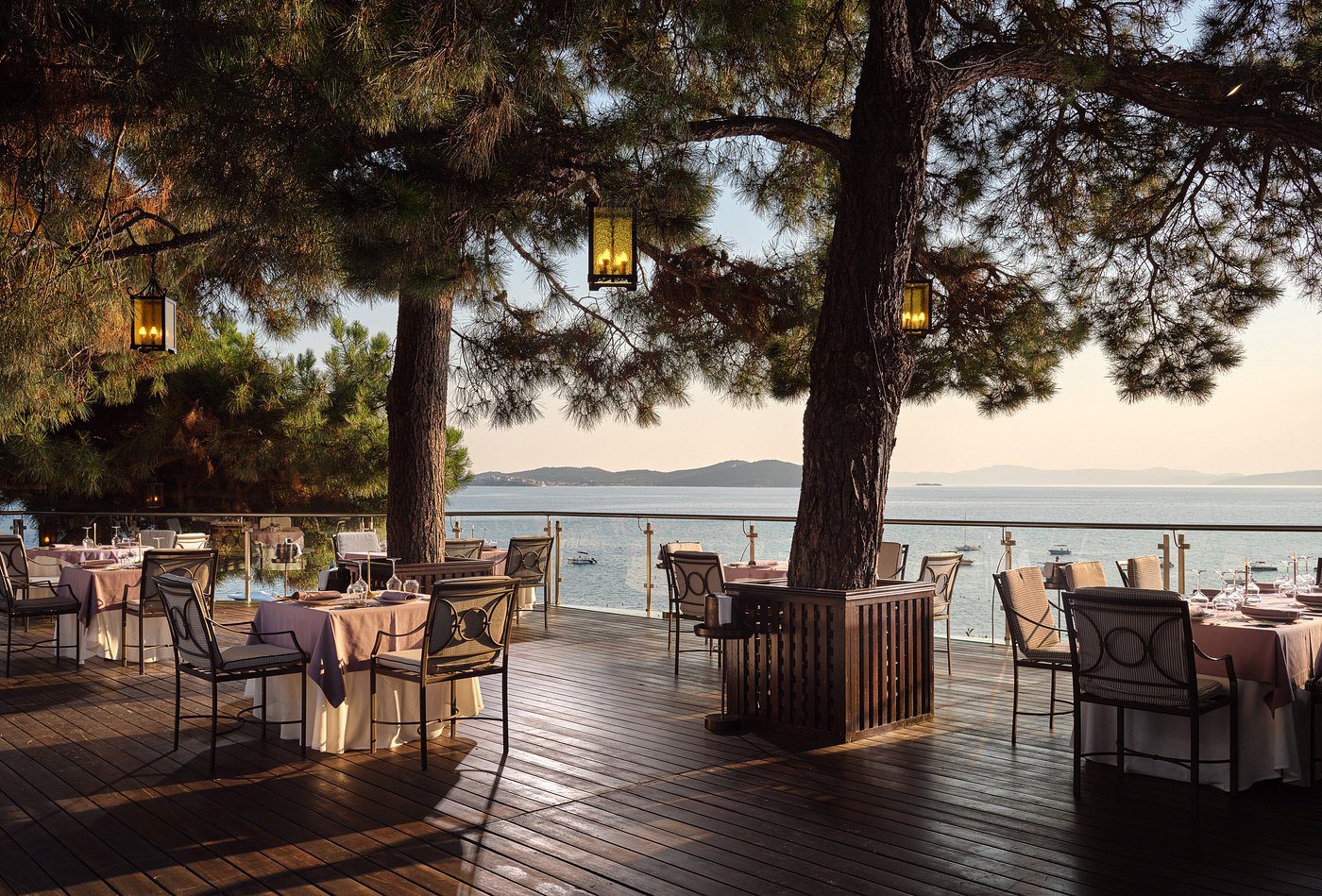Cozy outdoor dining area with sea view at sunset.