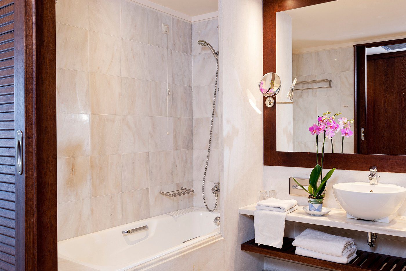 Clean bathroom with bathtub, shower, and vanity mirror.