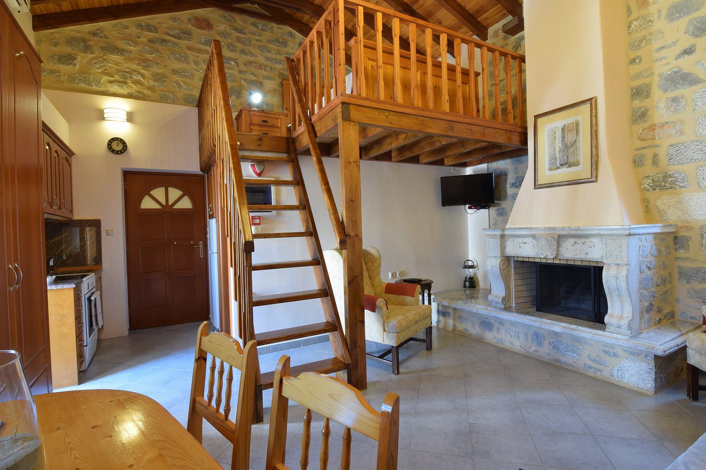 Cozy living room with wooden loft and staircase.