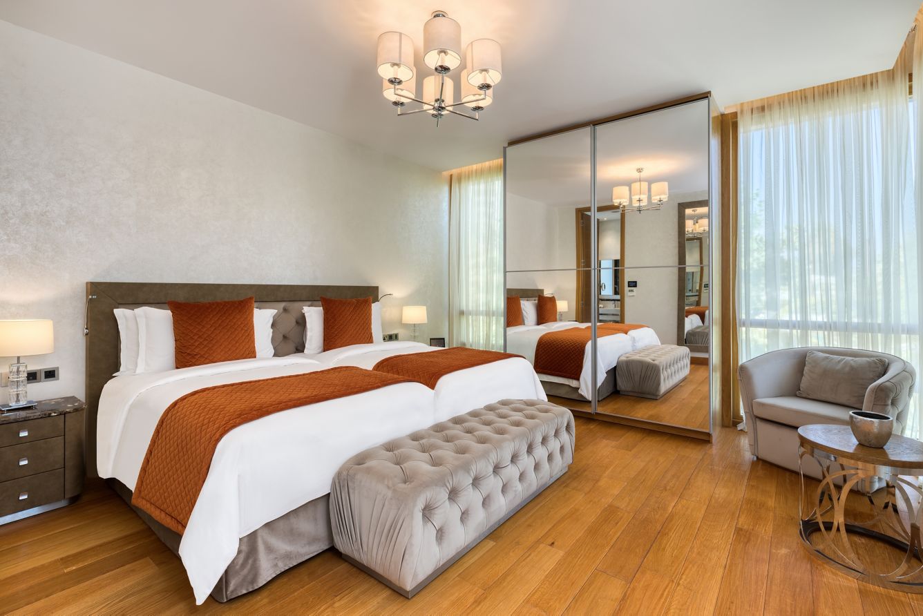Elegant bedroom with twin beds and mirrored closet doors.
