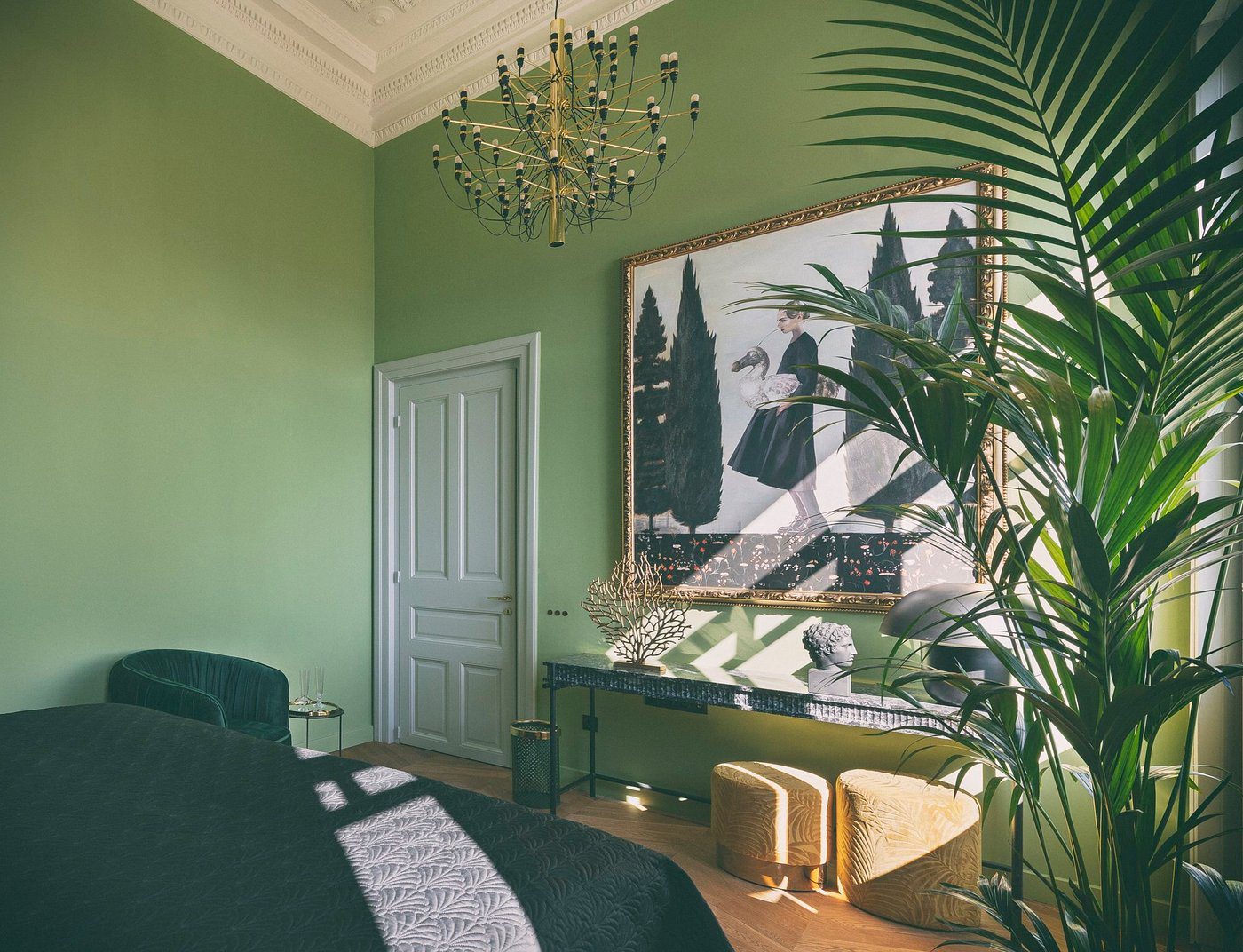 Sunlit green bedroom with modern decor and plants.