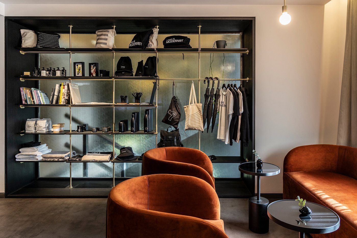 Cozy seating area with stylish rust-colored chairs and a modern open wardrobe.