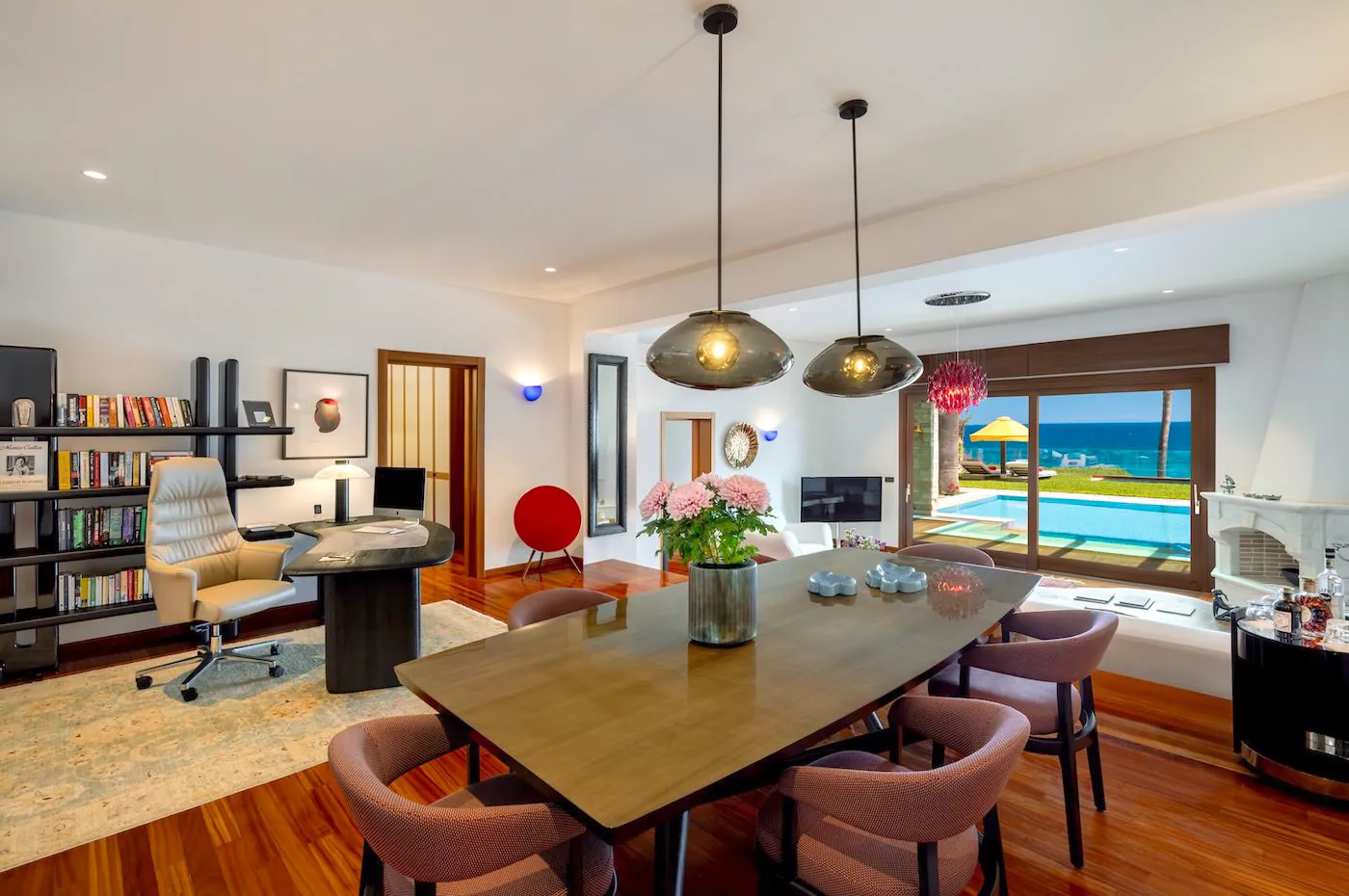 Modern dining area with stylish pendant lights and ocean view.