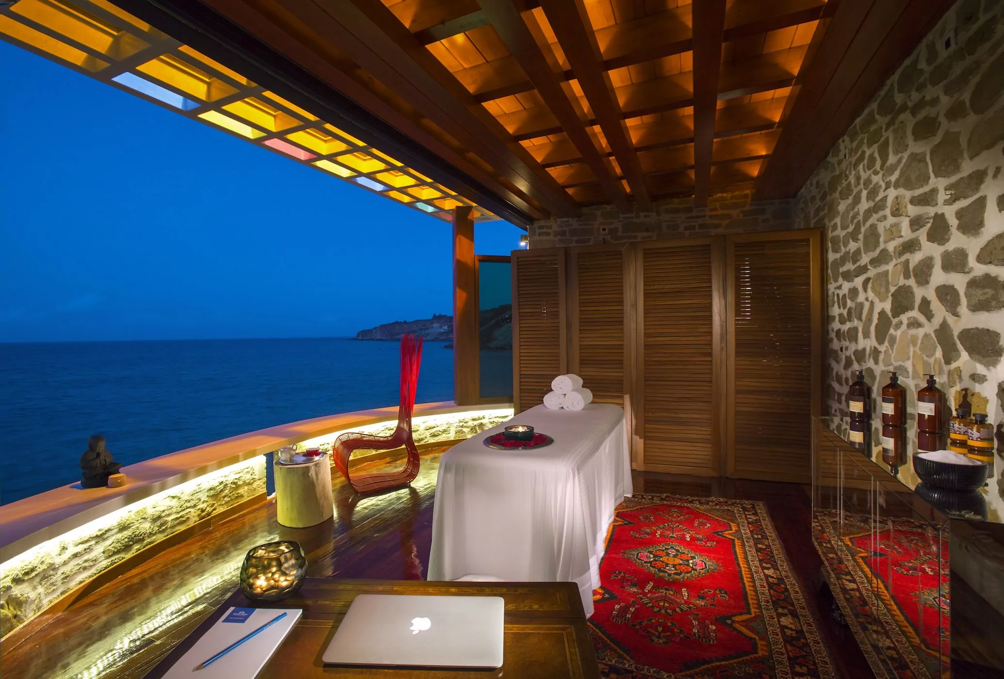 Cozy outdoor lounge with ocean view at dusk.