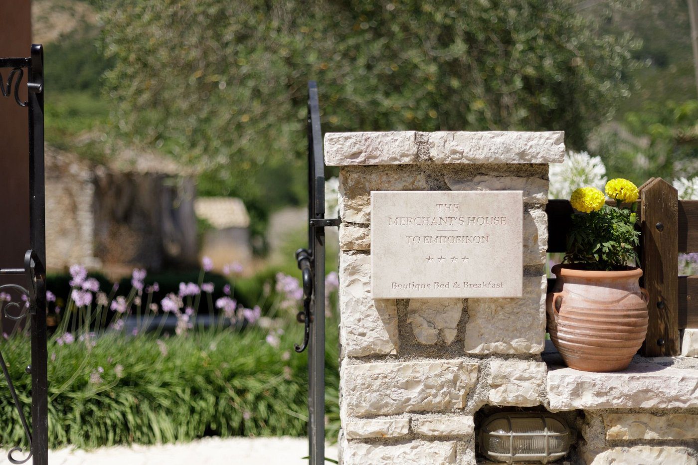 Stone signpost at a park entrance with greenery in the background.