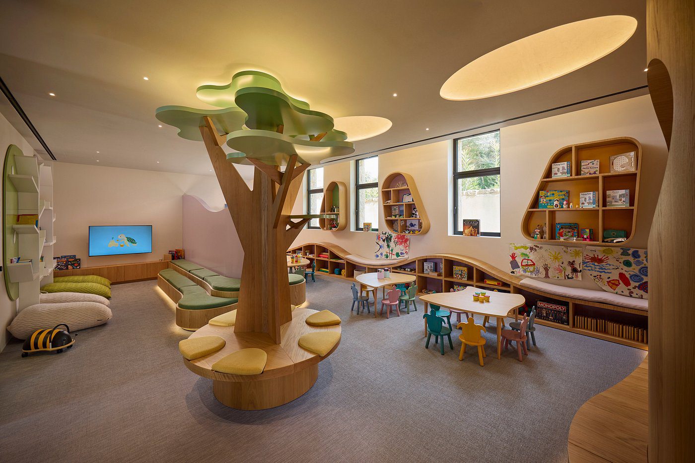 Children's playroom with a tree-shaped climbing structure and cozy seating.