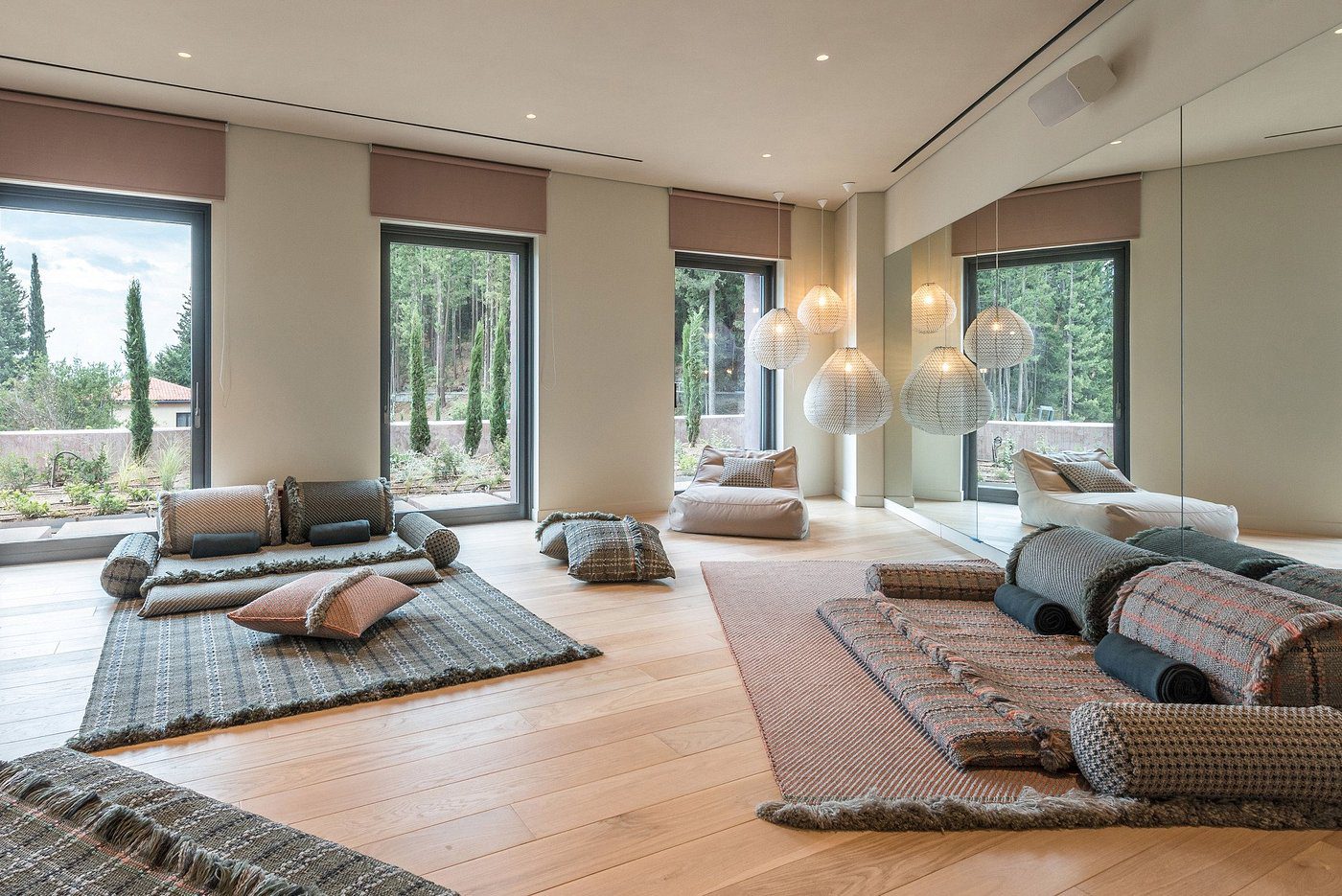 A serene yoga and meditation room with large windows and natural light.