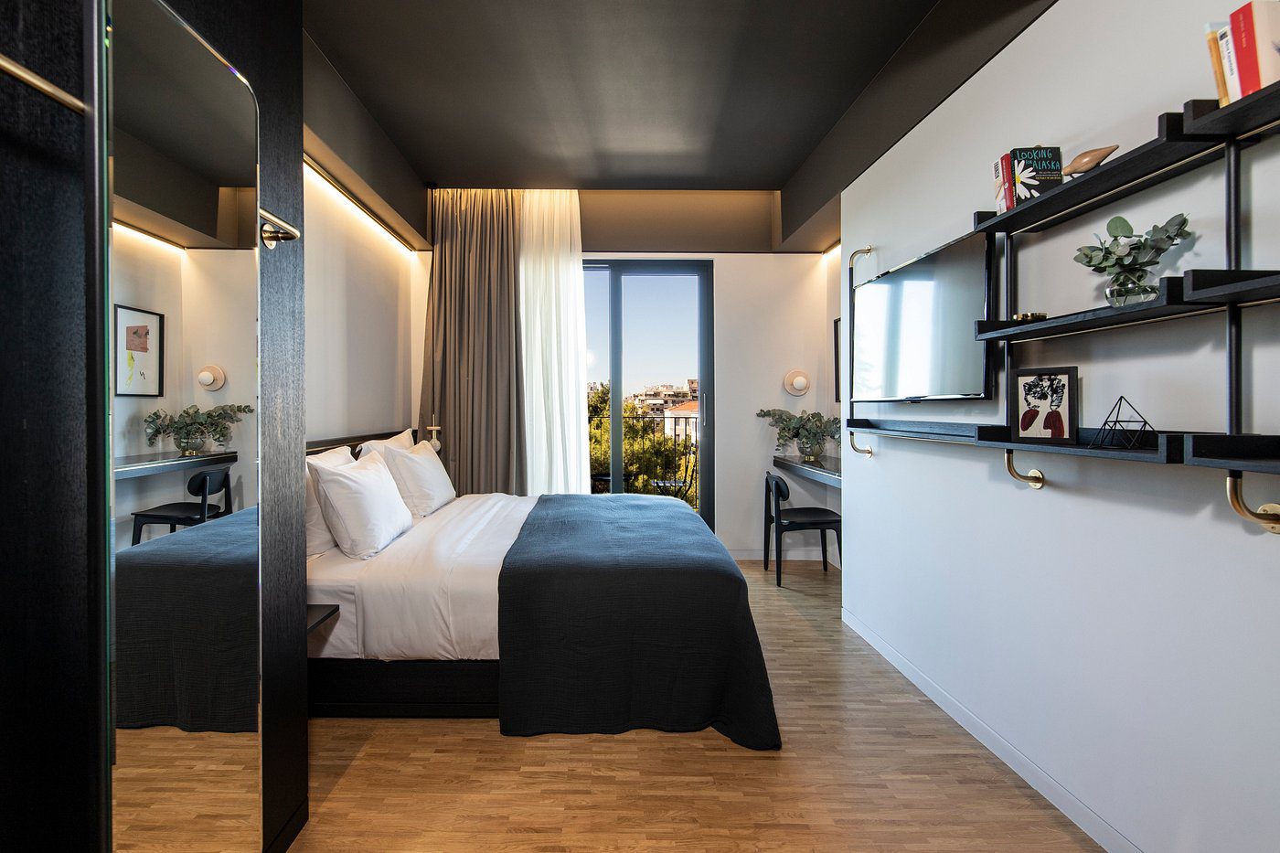 Modern bedroom with a large window and cozy bed setup.