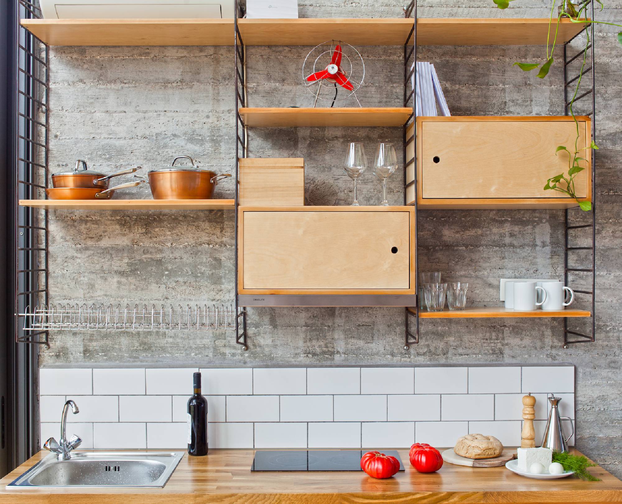 Modern kitchen with wooden shelves and white subway tiles.