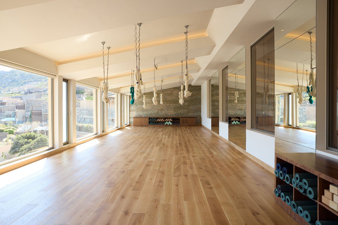 Spacious, modern room with wooden flooring and pendant lights.
