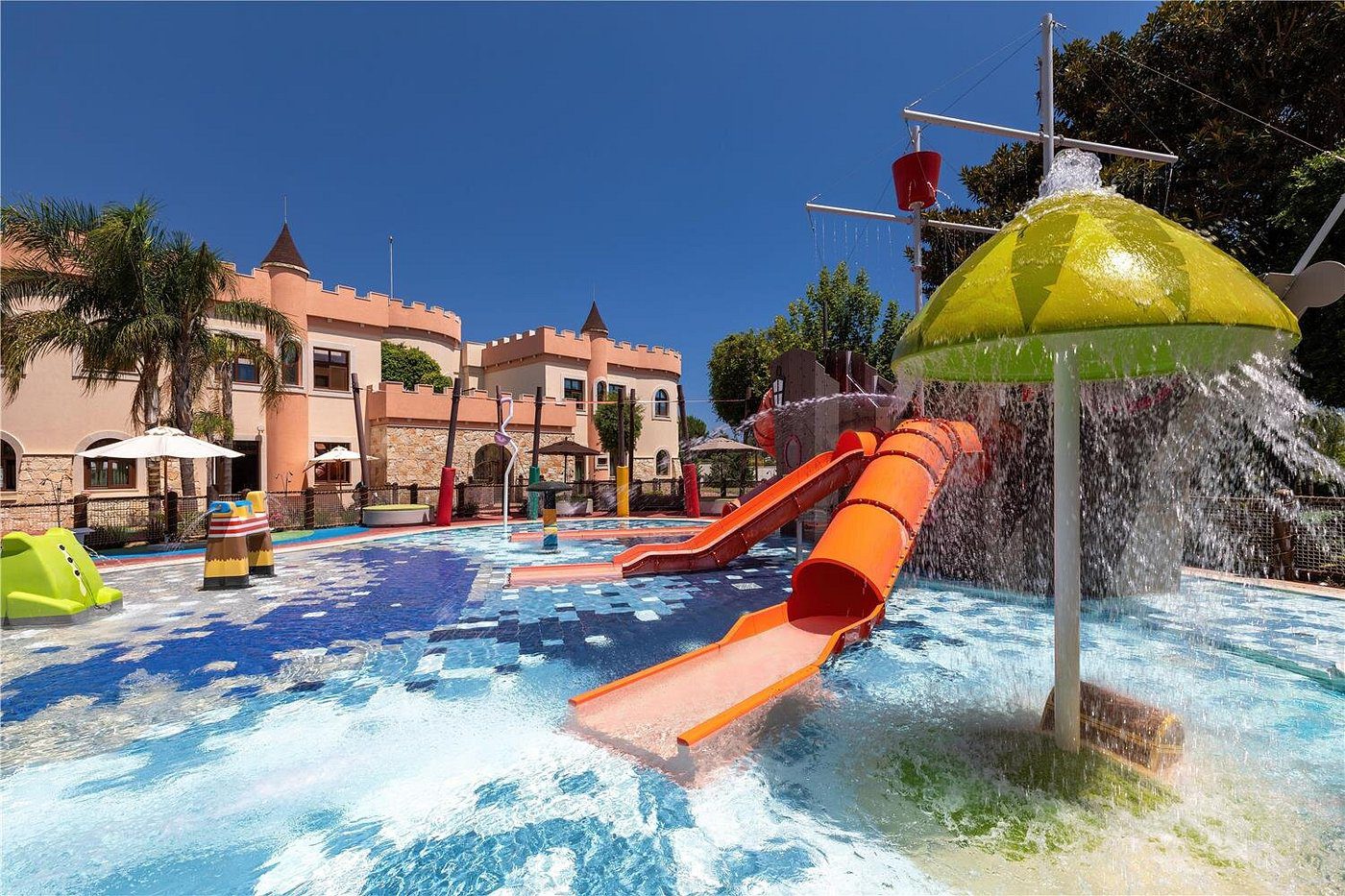Colorful water slides and fountains at a sunny water park.