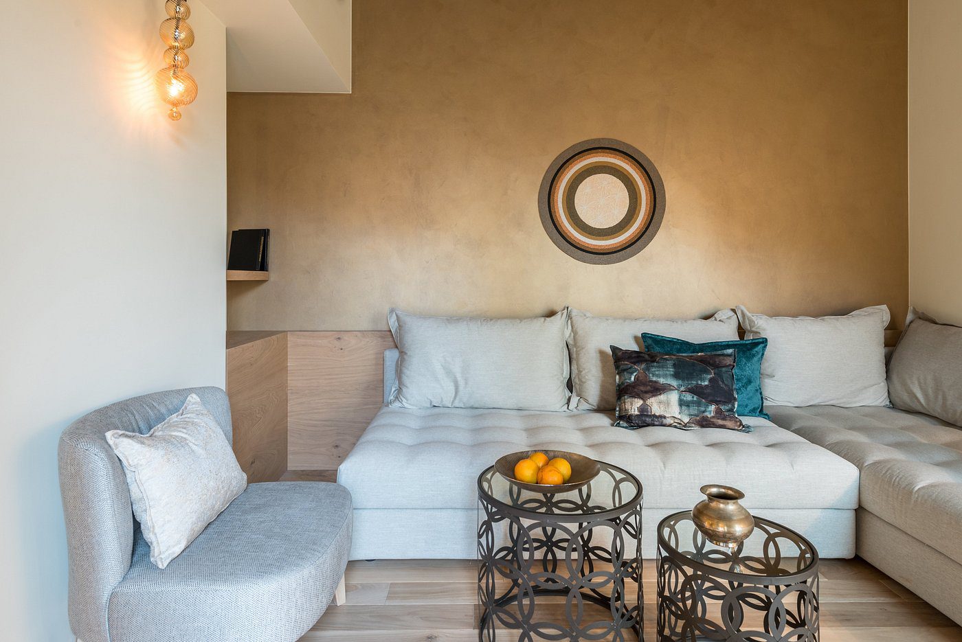 Cozy modern living room with light cushions and decorative round tables.