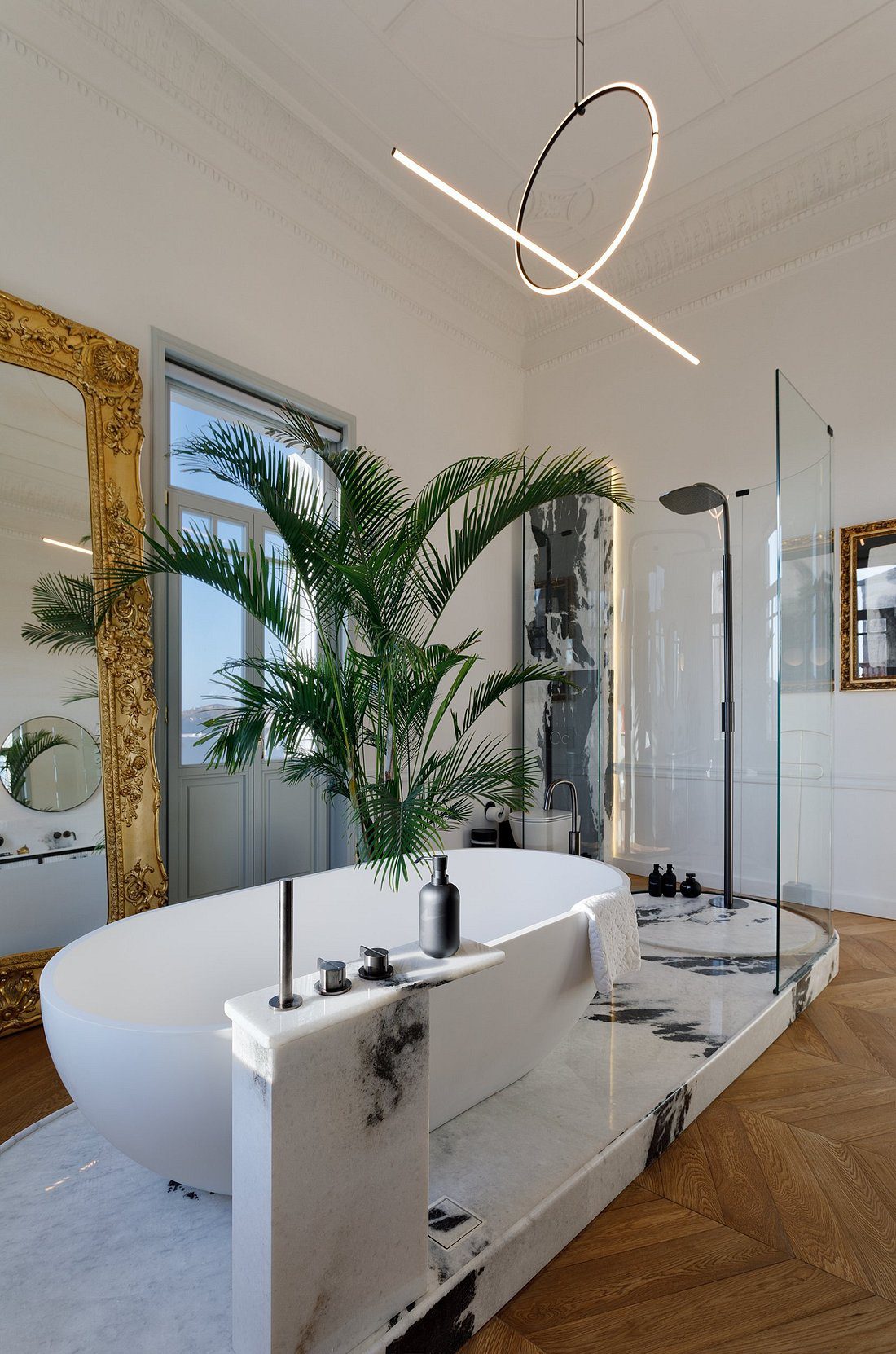 Modern bathroom with a freestanding tub and large mirrors.