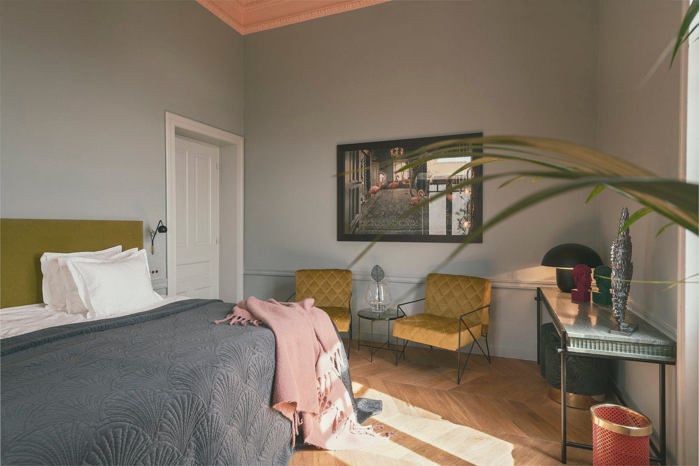 Cozy bedroom corner with two mustard-yellow chairs and a framed window artwork.
