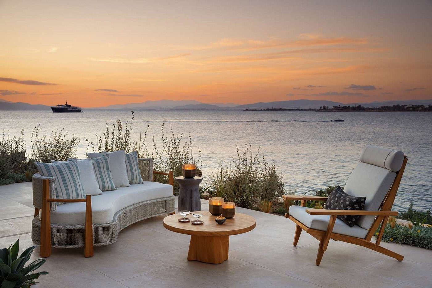 Cozy outdoor seating area overlooking a serene sunset on the water.