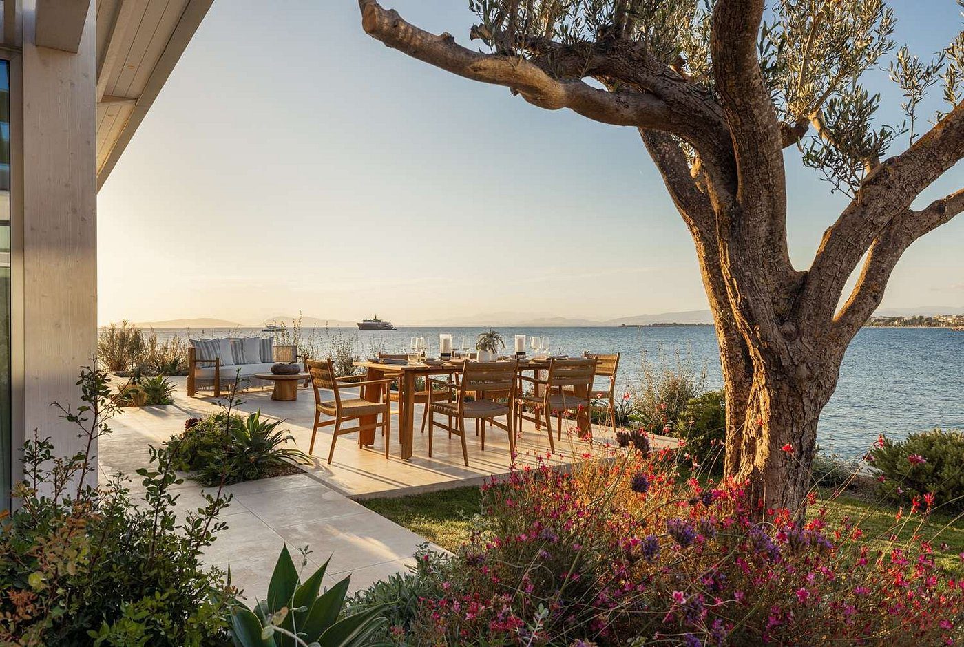 Cozy outdoor dining area overlooking the serene sea at sunset.