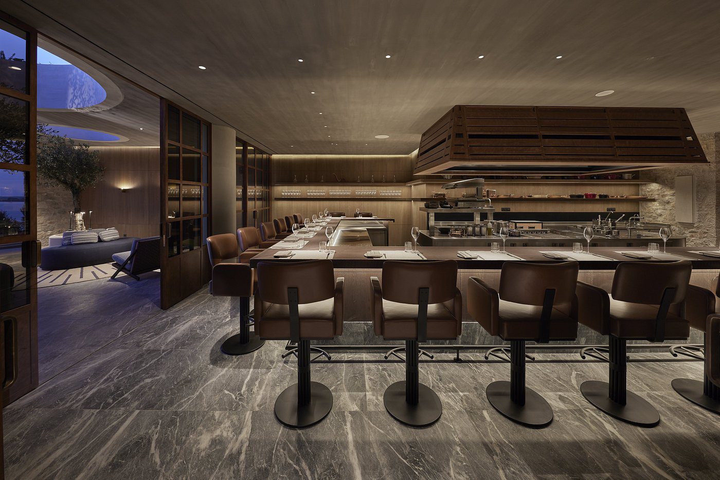 Modern bar with leather stools and ambient lighting.