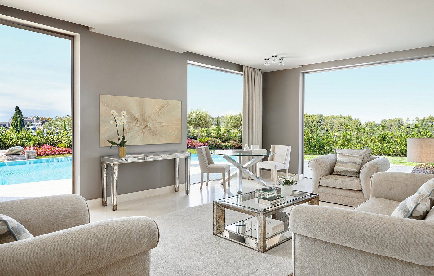 Bright, modern living room with large windows and neutral decor.