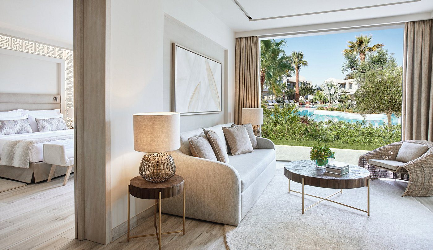 Bright living room with white sofa and pool view.