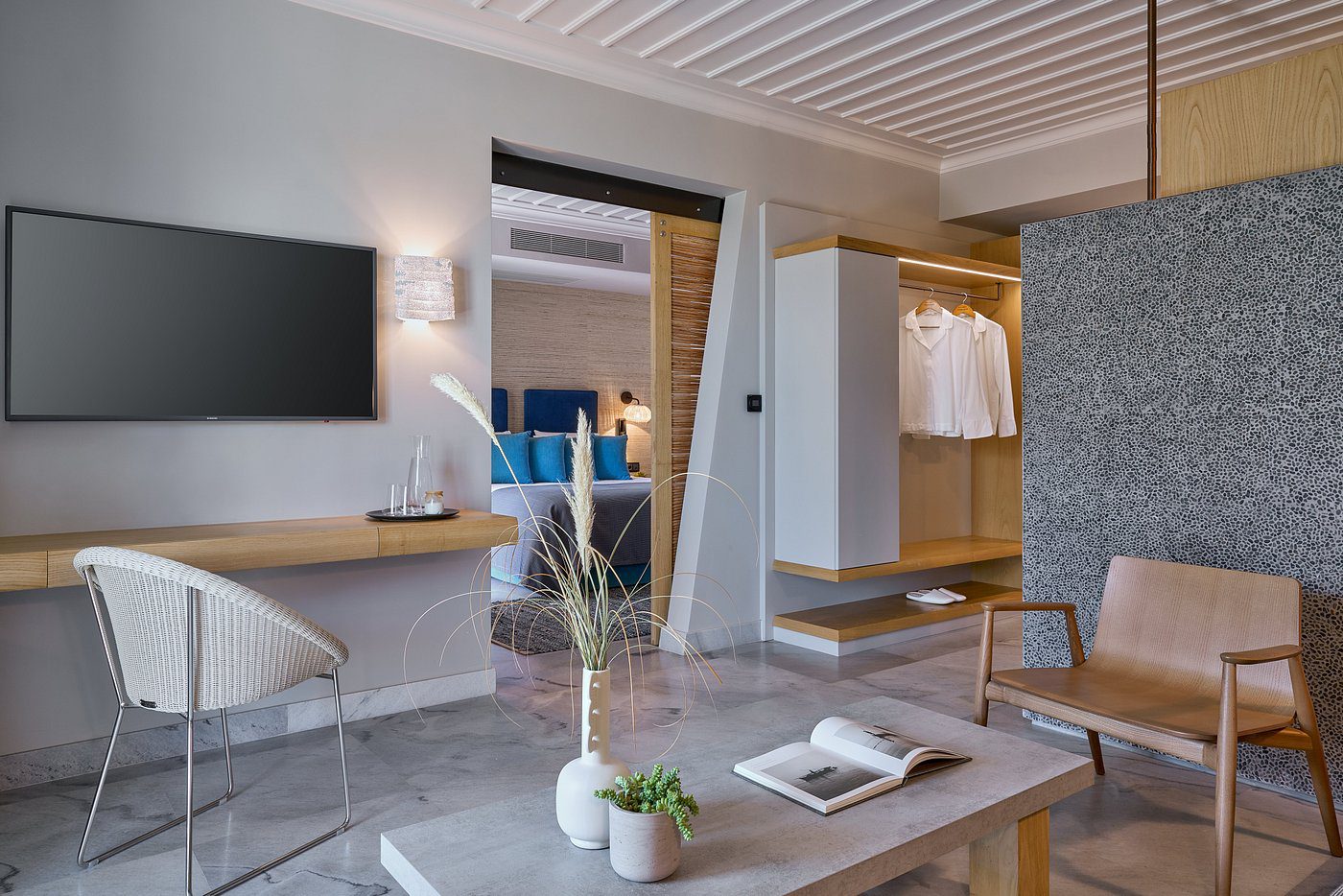 Modern hotel room with a cozy sitting area and a sleek bathroom.